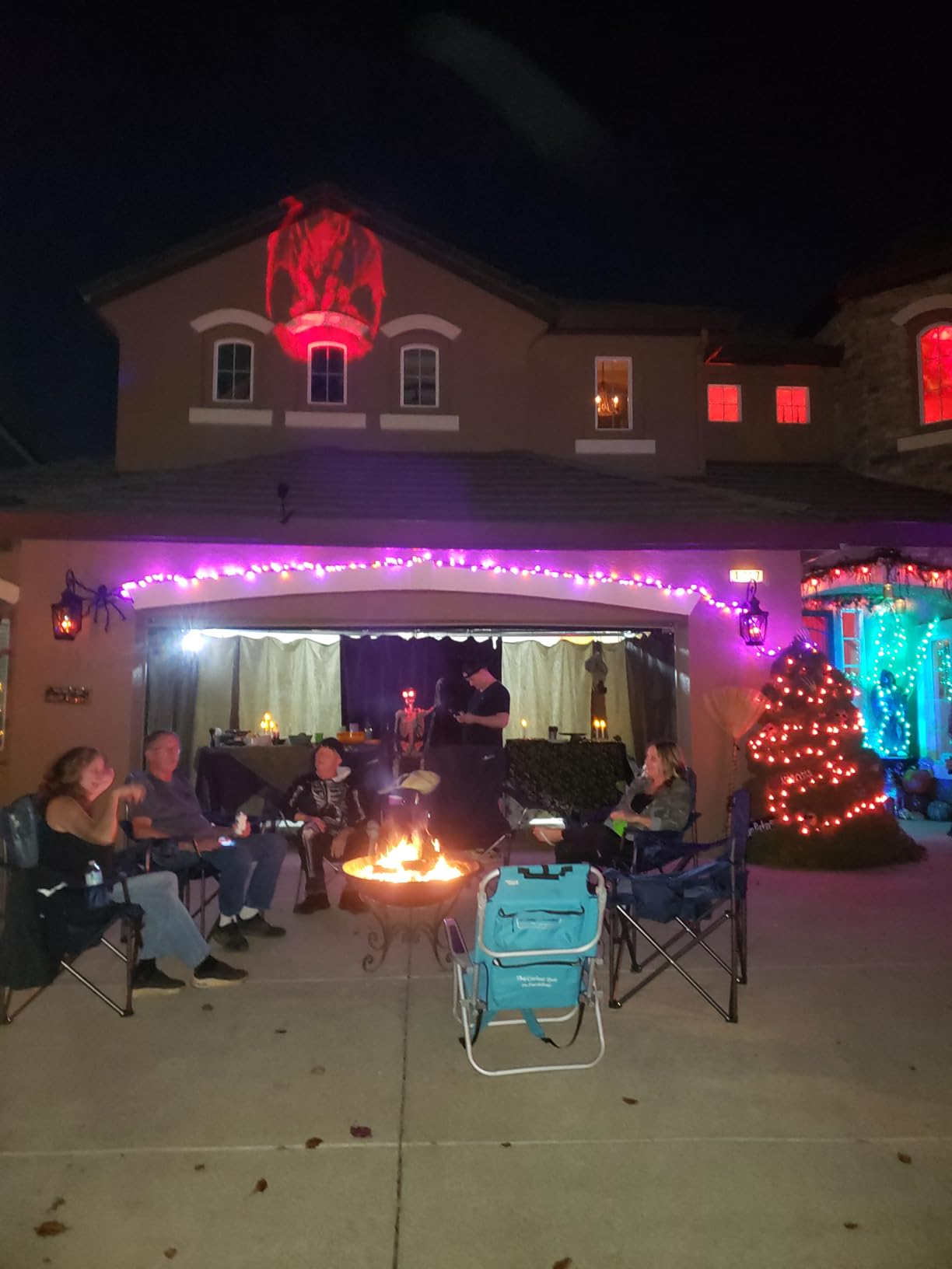 Customer's house glowing during a Halloween firepit party